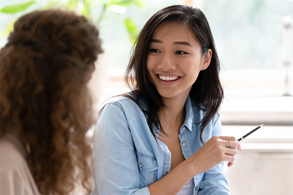Two high school students talking in classroom setting