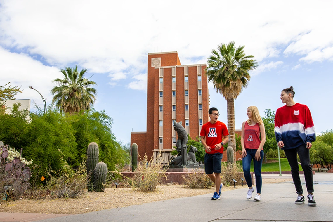 Three students walking on UA campus together
