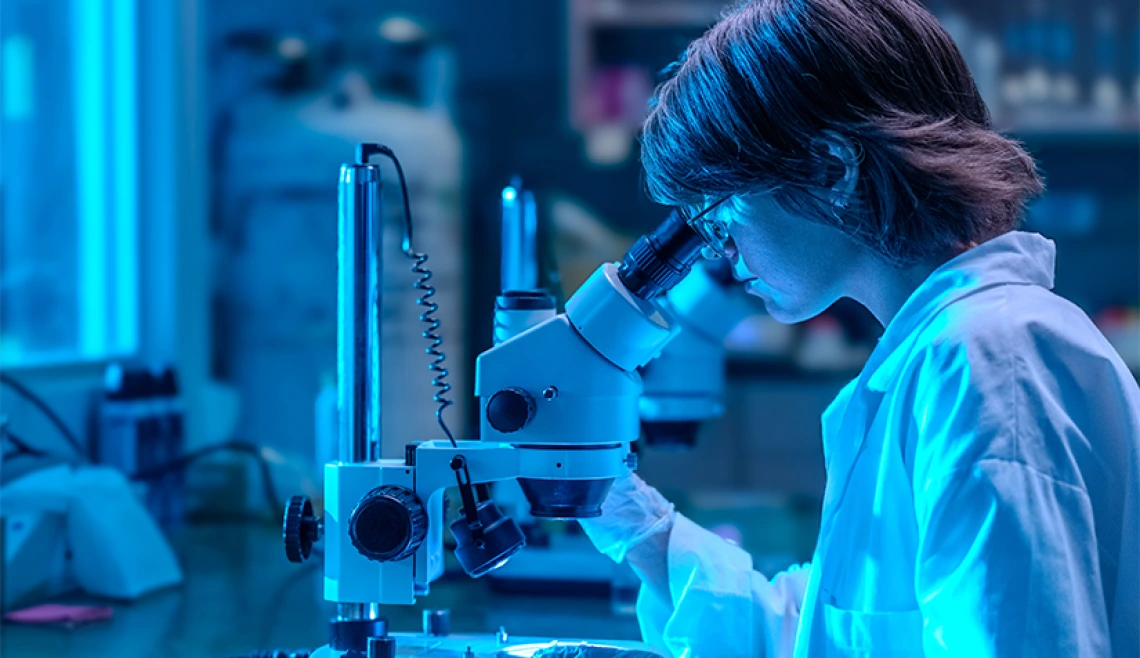 Science student looking into microscope