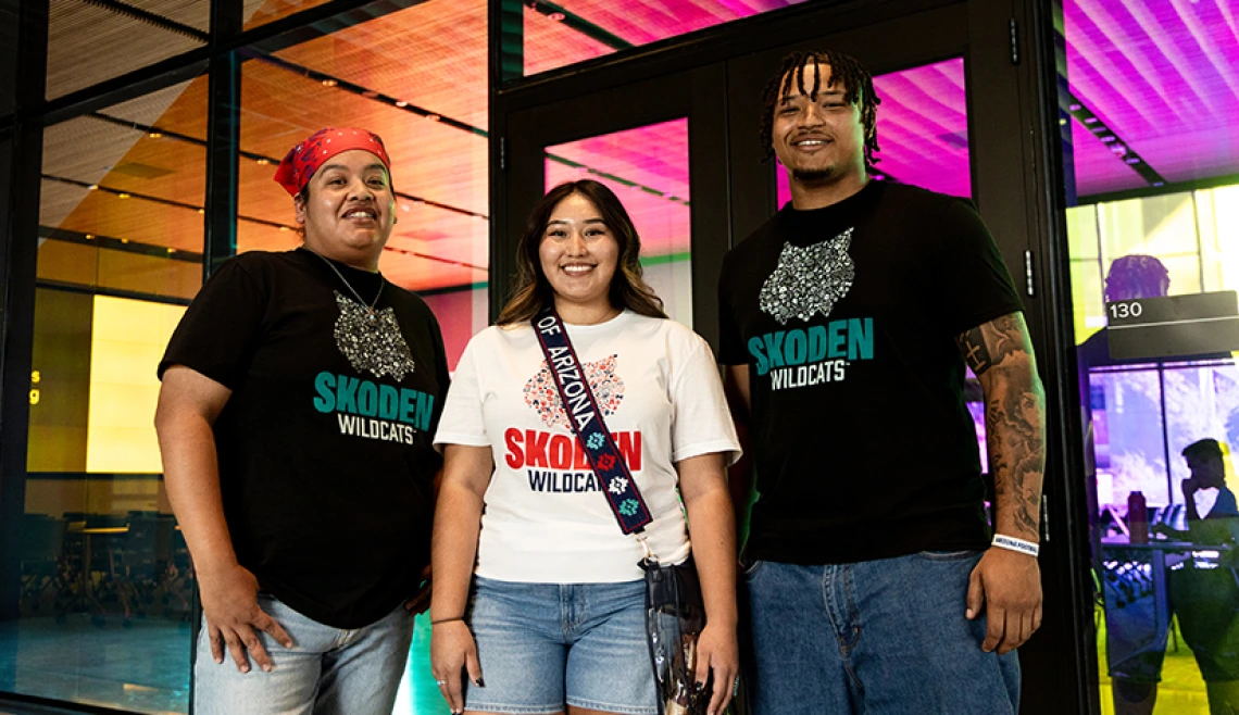 Three students standing outside campus building