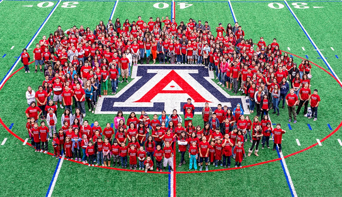 Group of UA students standing on football field