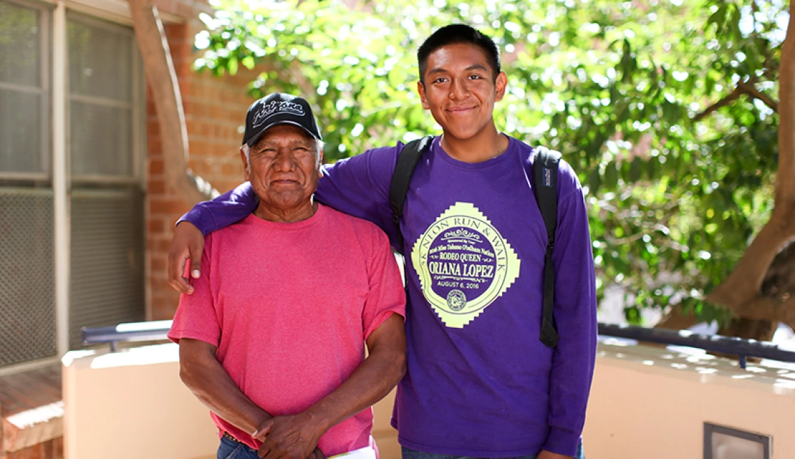 Student posing with parent outside